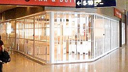 People in Alexandria international airport walking past a vision glass sliding security shutter
